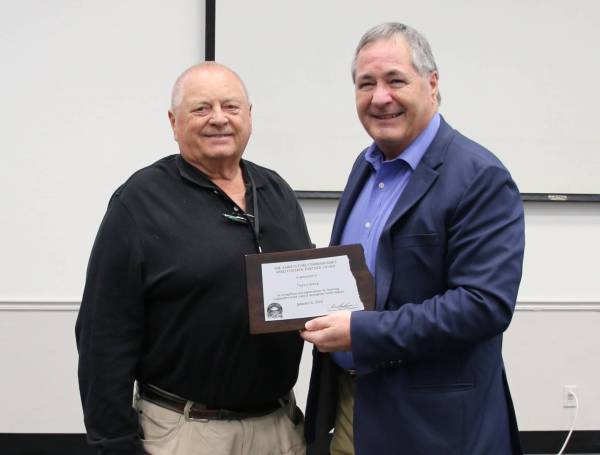 Terry Weis accepts the 2026 Weed Control Partner Award from Agriculture Commissioner Doug Goehring