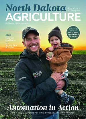 The 2025 cover of the North Dakota agriculture magazine depicting a potato farmer holding his young son